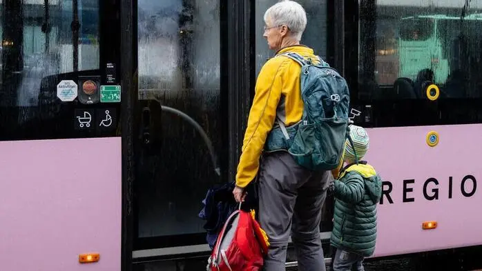 Eine Oma und ein Kind steigen in einen Bus ein