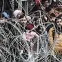 This picture taken from the Greek side of the Greece-Turkey border near Kastanies, shows migrants waiting on the Turkish side on March 2, 2020. - Greece was on a state of alert on March 1, 2020 as it faced an influx of thousands of migrants seeking to cross the border from Turkey, with locals fearing a new immigration crisis. More than 13,000 migrants have gathered on the Turkish side of the river which runs 200 kilometres (125 miles) along the frontier and separates them from Greece and therefore the European Union. The flow of migrants from Turkey has triggered EU fears of a re-run of the 2015 migrant emergency when Greece became the main EU entry point for a million migrants, most of them refugees fleeing the Syrian civil war. (Photo by Sakis MITROLIDIS / AFP)