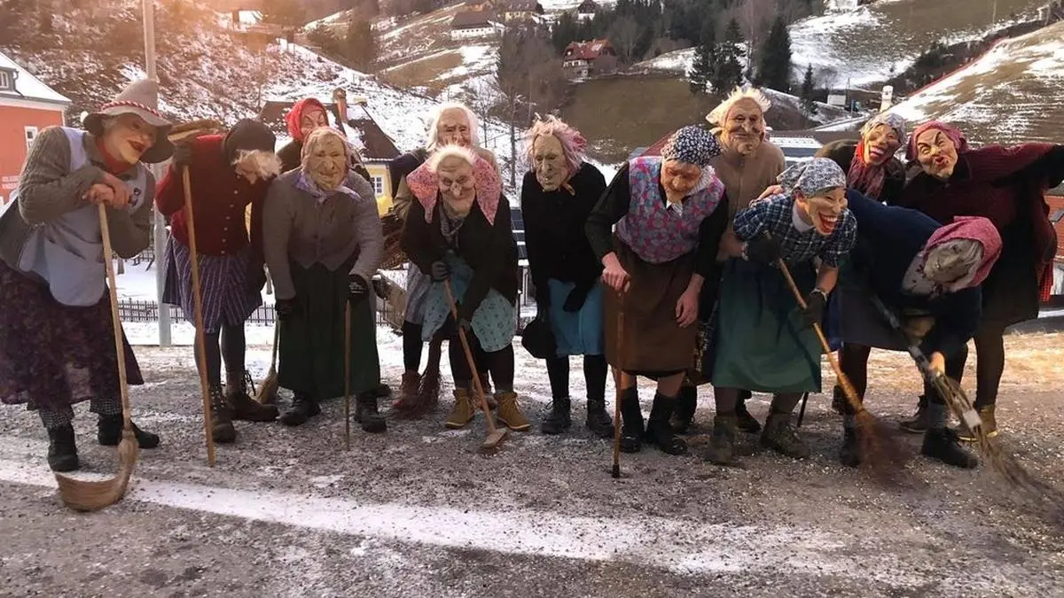 Gebückt, mit tief ins Gesicht gezogener Mütze und Besen tritt die Pudelmutter auf	