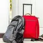 red travel bag , backpack and shoes by front door 