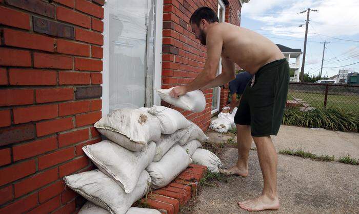 Küstenbewohner brachten Spanplatten vor ihren Fenstern an und füllten Sandsäcke, um ihre Häuser vor Sturm und Wassermassen zu schützen