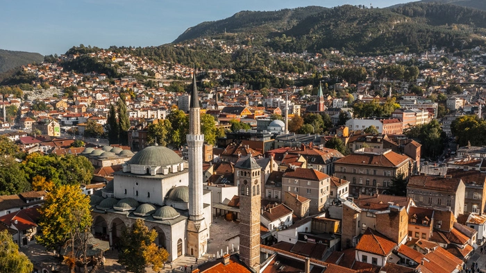 Die Hauptstadt von Bosnien und Herzegowina mit ihren knapp 300.000 Einwohnern ist seit jeher ein bedeutender Schmelztiegel von Volksgruppen, Kulturen und Religionen. Beim Klang des Muezzins, Blick auf Minarette und duftendem Kaffee aus Kupferkännchen hört man den Takt der lebhaften Stadt schlagen. Das Basarviertel Baščaršija sollte für jeden Besucher auf der Prioritätenliste stehen. Am besten schaut man gleich zwei Mal vorbei: einmal tagsüber, um das bunte Treiben zu erleben, und einmal abends, um die Lichter zu bewundern. Im Tunnelmuseum erfahren Interessierte mehr über den Bosnienkrieg und den Schrecken der 1425 Tage andauernden Belagerung der Stadt durch die serbische Armee. Im Zentrum stoßen Besucher immer wieder auf rote Farbspritzer auf dem Boden. Dabei handelt es sich um die sogenannten Rosen von Sarajevo, die markieren, wo ein Mensch in der Zeit der Belagerung durch Schüsse zu Tode gekommen ist. 