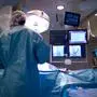 A cardiologist implants a heart defibrillator in a patient. Focus is on the fluoroscopy monitors. (14MP camera, real operation).