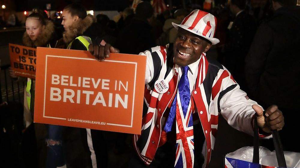 Demonstranten vor dem britischen Parlament freuen sich über das Votum