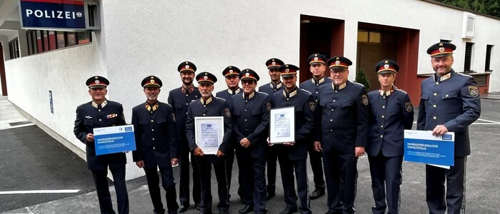 Dreizehn Polizisten stehen in Reih und Glied vor einer Polizeistation