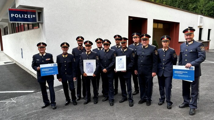 Dreizehn Polizisten stehen in Reih und Glied vor einer Polizeistation
