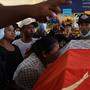 Die Mutter eines von den Sicherheitskräften bei den Protesten erschossenen Teenagers steht weinend am Sarg ihres Sohnes