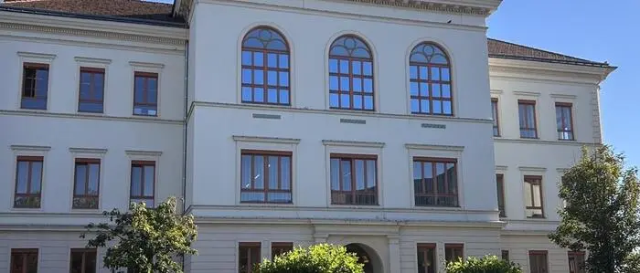 Lediglich die hohen Bogenfenster an der Westseite verfügen über keine Außenrollos. Dahinter befinden sich aber keine Schulräume, sondern der Bürgersaal