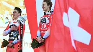 Second-placed Switzerland's Franjo Von Allmen (L) and first-placed Switzerland's Marco Odermatt celebrate on the podium after the men's Downhill event at the FIS Alpine Skiing World Cup in Wengen on January 18, 2025. (Photo by FABRICE COFFRINI / AFP)