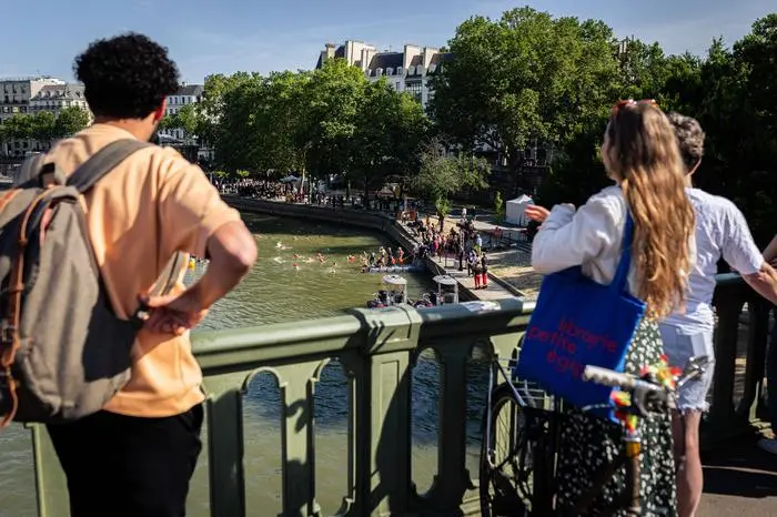 July 17, 2024, Paris, France: People gather on the Sully Bridge to watch the Mayor of Paris, Anne Hidalgo, swim in the River Seine. Paris Mayor Anne Hidalgo swims in the Seine River at Bras Marie with Marc Guillaume, Prefect of the Ile-de-France region and Tony Estanguet, President of Paris 2024, in Paris. Ten days before the start of the Olympic Games, the mayor of Paris has kept her promise and dived into the River Seine, to demonstrate the efforts of the city to improve the quality of the water of Seine. Paris France - ZUMAs197 20240717_aaa_s197_219 Copyright: xTelmoxPintox