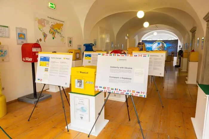 Die österreichische Version zeigt die ukrainische Flagge und den Schriftzug „Hilfe für die Ukraine“.  Die Ausstellung kann bis zum 6. Juli 2024 im Postmuseum Eisenerz besucht werden, danach wandert sie weiter nach Kroatien.