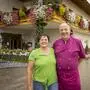 Eine Frau und ein Mann stehen vor ihrem Gasthof, der mit vielen Blumen geschmückt ist | Die Gastwirte Martha und Helmut Schliefnig vor dem Thürnerwirt