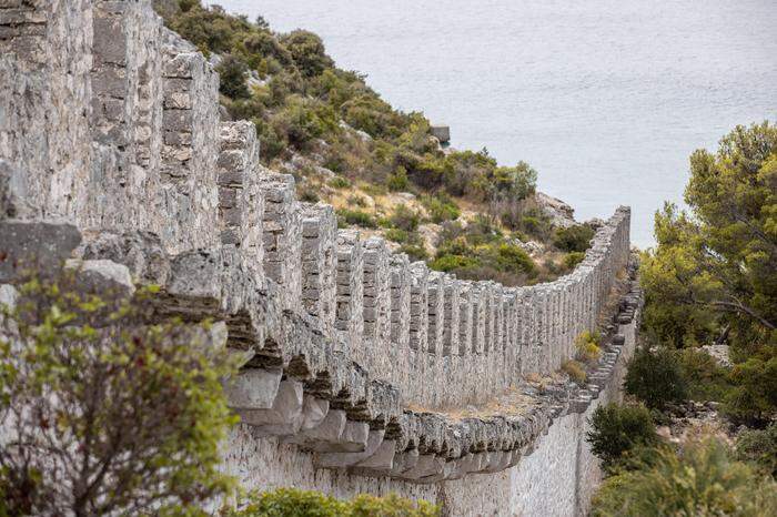 „Eisernen Vorhang“ aus Stein. Die bis zu zehn Meter hohe Mauer trennt die Halbinsel vom Ort Grebaštica