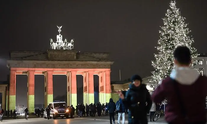 The Brandenburg Gate is seen illuminated in the colors of the German flag during a rehearsal ahead of the official remembrance ceremony in Berlin on December 20, 2016, a day after a terror attack on a Christmas market.   / AFP PHOTO / CLEMENS BILAN