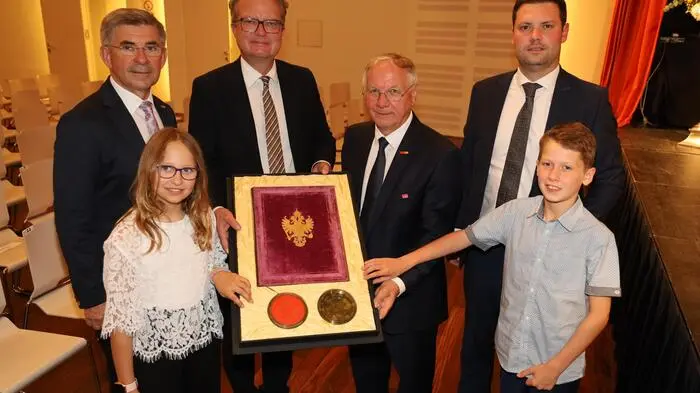 Landtagsabgeordneter Franz Fartek, Landeshauptmann Christopher Drexler, Bürgermeister Josef Ober, Amtsdirektor Philipp Huemer sowie Kinderbürgermeisterin Hannah Tappauf und Kinderbürgermeister Kevin Friedl mit der Stadterhebungsurkunde