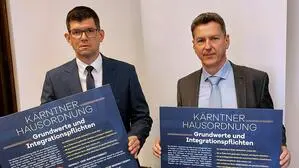 Martin Gruber (ÖVP) und Daniel Fellner (SPÖ) mit der „Kärntner Hausordnung“
