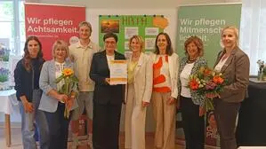 Sieben Frauen und ein Mann lachen in die Kamera