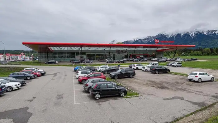 Ein großer Parkplatz mit einer dahinterliegenden Geschäftsfläche