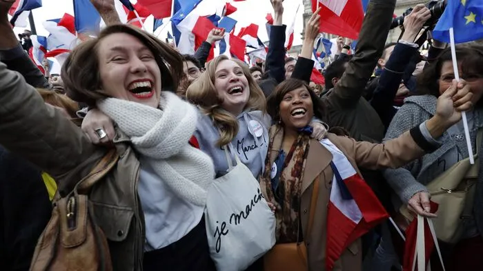 "Macron, Président", rufen seine Unterstützer, die sich am Louvre versammelt haben und seit Stunden auf ihn warten...