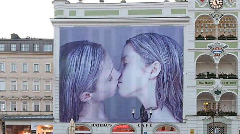 Kunstinstallation von Gottfried Helnwein | Das riesige Bild zweier sich küssender Mädchen verhüllt aktuell einen Teil des Rathauses in Gmunden