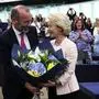 Ursula von der Leyen (R), a nominee for a second term as president of the European Commission receives flowers from  with EU Parliament's political group European People's Party (EPP) President, Manfred Weber (L) at the European Parliament in Strasbourg, eastern France, on July 18, 2024. EU lawmakers on July 18 handed Ursula von der Leyen another five-year term as European Commission president during their first parliamentary session since June elections. Von der Leyen won with the support of 401 MEPs in the 720-seat chamber -- comfortably over the 361-vote majority she needed to remain head of the EU's executive body. There were 284 who voted against in the secret ballot. (Photo by FREDERICK FLORIN / AFP)