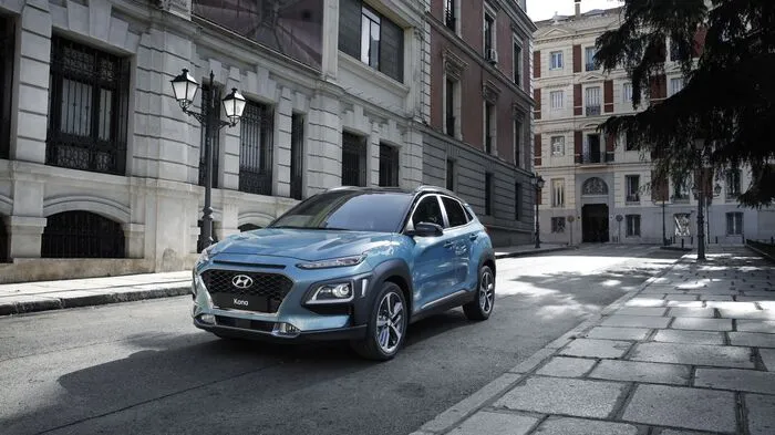 Die markante Front des Hyundai Kona ist geprägt vom Kaskaden-Kühlergrill und über den Frontscheinwerfern positionierte LED-Tagfahrlichter. Die Linien sind mutig scharf gezogen, die Karosserieüberhänge kurz und die Radhäuser, in denen sich Felgen bis zu einer Größe von 18 Zoll finden, kräftig betont. Zur kompakten Außenlänge von 4,17 und einer Höhe von 1,55 Metern gesellen sich mit 1,80 Metern Breite und einem Radstand von 2,60 Metern gute Voraussetzungen für reichlich Platz im Innenraum. Das Gepäckraumvolumen beträgt großzügige und praxistaugliche 361 Liter.