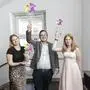 Ein Mann und zwei Frauen halten einen Pokal in die Luft