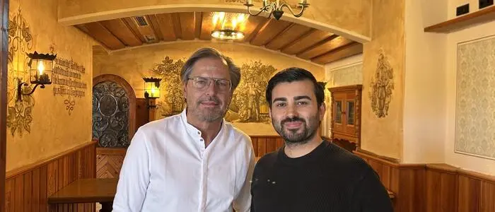 Zwei Männer stehen in einer alten, renovierten Gaststätte