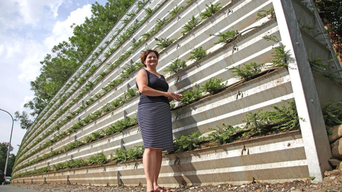 Ölmühlen-Inhaberin Julia Fandler vor der bepflanzten Lärmschutzwand in Pöllau