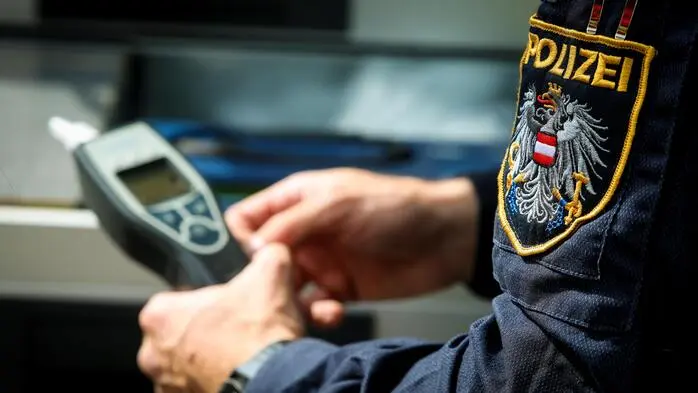 Ein Alkomat wird von einem Polizisten in Händen gehalten