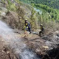 Die Arbeiten im steilen Gelände sind herausfordernd, die Bergrettung sichert die Feuerwehrleute