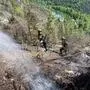 Die Arbeiten im steilen Gelände sind herausfordernd, die Bergrettung sichert die Feuerwehrleute