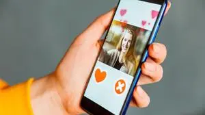 Online dating app in smartphone. Person swiping and liking profiles on relationship site or application. Single guy searching for love partner.