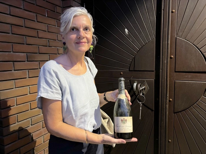 Beatrix Vreča mit einer antiken Flasche Bouvier bei der Stadtführung zum Thema Wein