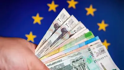 Abstract  concept  idea:  Bunch  of  ruble  banknote  in  a  hand  in  front  of  symbolic  europa xkwx background,  bank,  banking,  banknote,  bunch,  business,  cash,  color,  concept,  counted,  currency,  debt,  economy,  eu,  europe,  european,  exchange,  finance,  financial,  flag,  hand,  hundred,  investment,  loan,  male,  money,  national,  paper,  pay,  payment,  ruble,  rubles,  russia,  russian,  sanctions,  sanctions  russia,  success,  symbol,  union,  vote