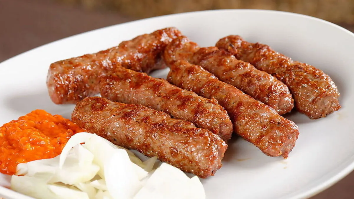 Traditionell mit Ajvar und Zwiebeln serviert: Ćevapčići