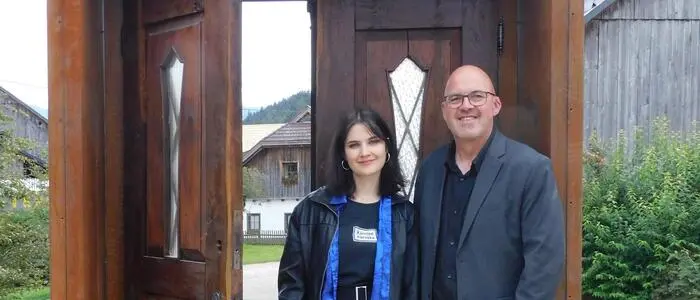 Ana Grilc und Daniel Mešnik beim Tor der Erinnerung, das zu einem Hof führt, von dem 1942 Menschen deportiert wurden