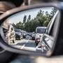 Blick in den Seitenspiegel eines Autos, zu sehen sind zwei stauende Pkw-Kolonnen