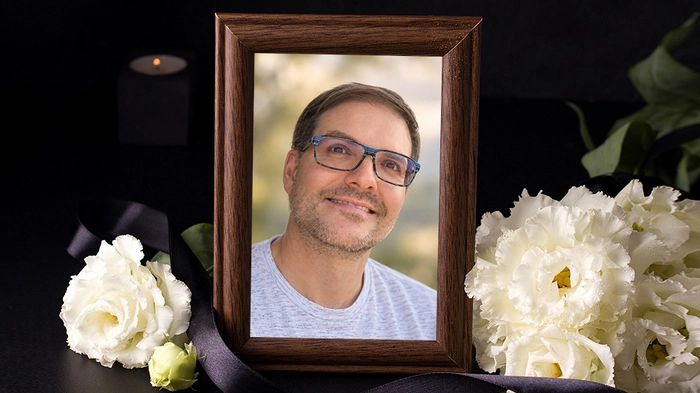 Ein gerahmtes Foto eines lächelnden Mannes mit Brille.