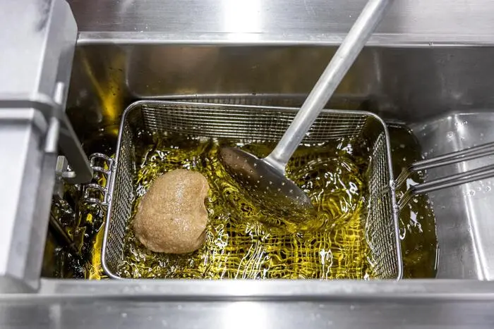 Durch das Frittieren der Krapfen bläst sich der Teig auf.