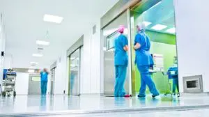 blurred figures wearing medical uniforms in hospital surgery corridor
