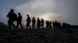 (FILES) Migrants walk by the jungle near Bajo Chiquito village, the first border control of the Darien Province in Panama, on September 22, 2023. The bodies of some 200 migrants who were heading to the United States and died while crossing the dangerous Darien jungle, which connects South America with Central America, remain unidentified in Panama, Panamanian authorities reported on August 27, 2025. (Photo by Luis ACOSTA / AFP)