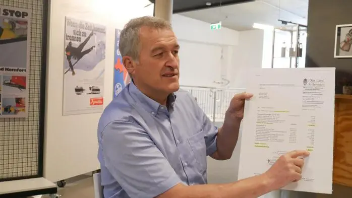 Karl Rudischer zeigt ein „Taferl“ mit der Mitteilung des Vorschusses der Ertragsanteile für den Monat Mai 2025