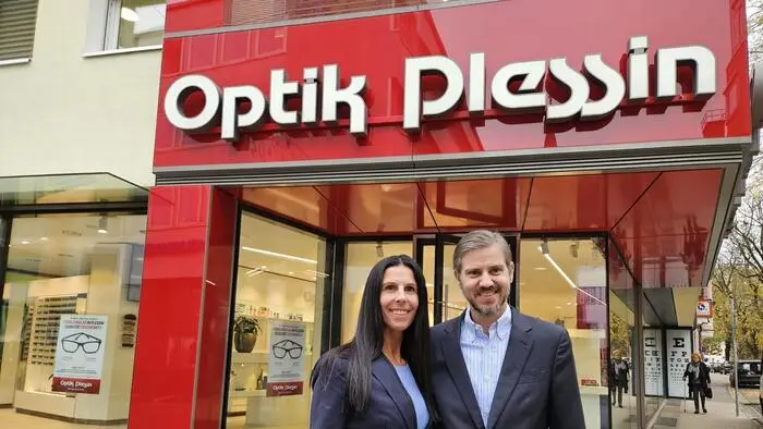 Eine Frau und ein Mann stehen vor einem Optikgeschäft