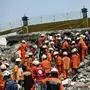 Myanmar and Chinese rescuers carry the body of a victim that was trapped under the rubble of the collapsed building 'Sky Villa Condominium development' in Mandalay on April 2, 2025, five days after a major earthquake struck central Myanmar. Days after a shallow 7.7-magnitude earthquake that killed more than 2,000 people, many people in Myanmar are still sleeping outdoors, either unable to return to ruined homes or afraid of further aftershocks. (Photo by Sai Aung MAIN / AFP)