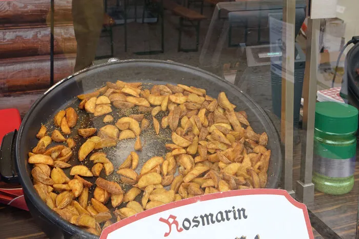 Frisch gemacht werden auch hunderte Kilo von verschiedenen frittierten Kartoffeln, um die sich zwei Frauen gegenüber kümmern. „Ich muss ehrlich sagen, ich verkaufe die Sachen zwar gerne, aber essen kann ich sie selbst nicht mehr“, sagt eine der beiden ehrlich und richtet voller Begeisterung eine Portion her.