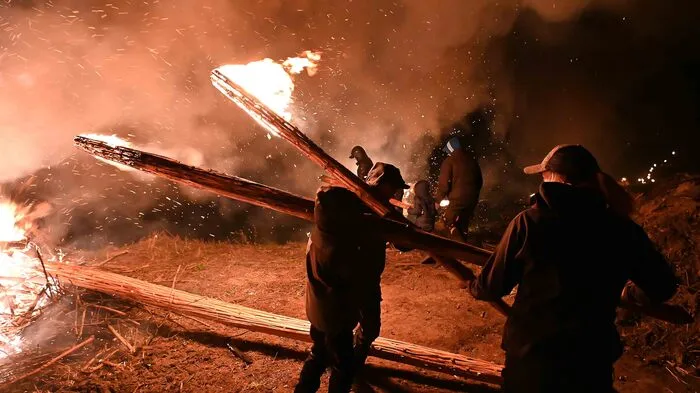 Frauen und Männer entzündeten am Karsamstag in Gösseling bei Launsdorf meterhohe Fackeln und trugen diese durch die dunkle Nacht.