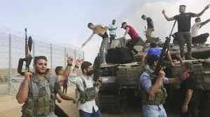 Palästinensische Bewaffnete auf einem israelischen Panzer