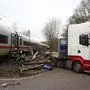A police officer looks on as firefighters work at the site of a collision between a lorry and an ICE  (InterCity Express) high-speed train of German railway operator Deutsche Bahn at a level crossing in the Roenneburg district of Hamburg, northern Germany on February 11, 2025. A train collided with a lorry at a crossing in northern Germany on Tuesday, leaving at least 12 people hurt, emergency services said. (Photo by Sebastian PETERS / NEWS5 / AFP)
