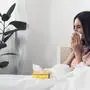 sick young woman with box of paper napkins sitting in bed

krank